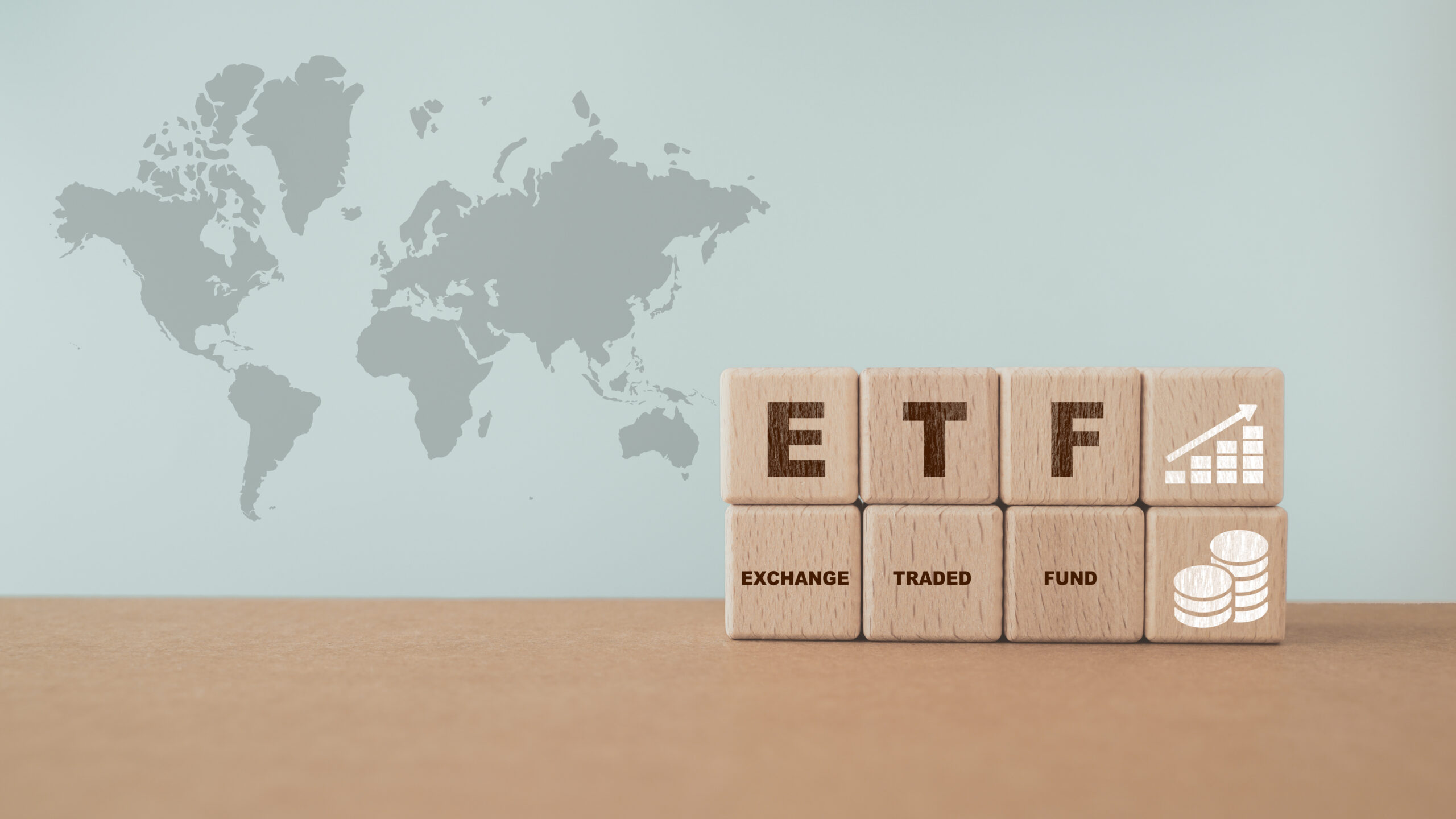 Cubes en bois avec texte ETF, Exchange Traded Fund, graphique croissant et icône sur fond de carte du monde. Pour le concept de la finance et la gestion de patrimoine