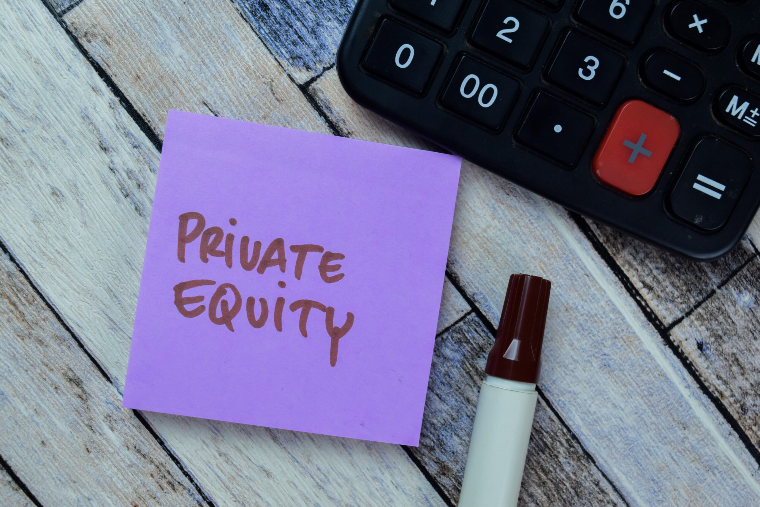 Post-it sur une table en bois, sur lequel est écrit "Private Equity" au marqueur