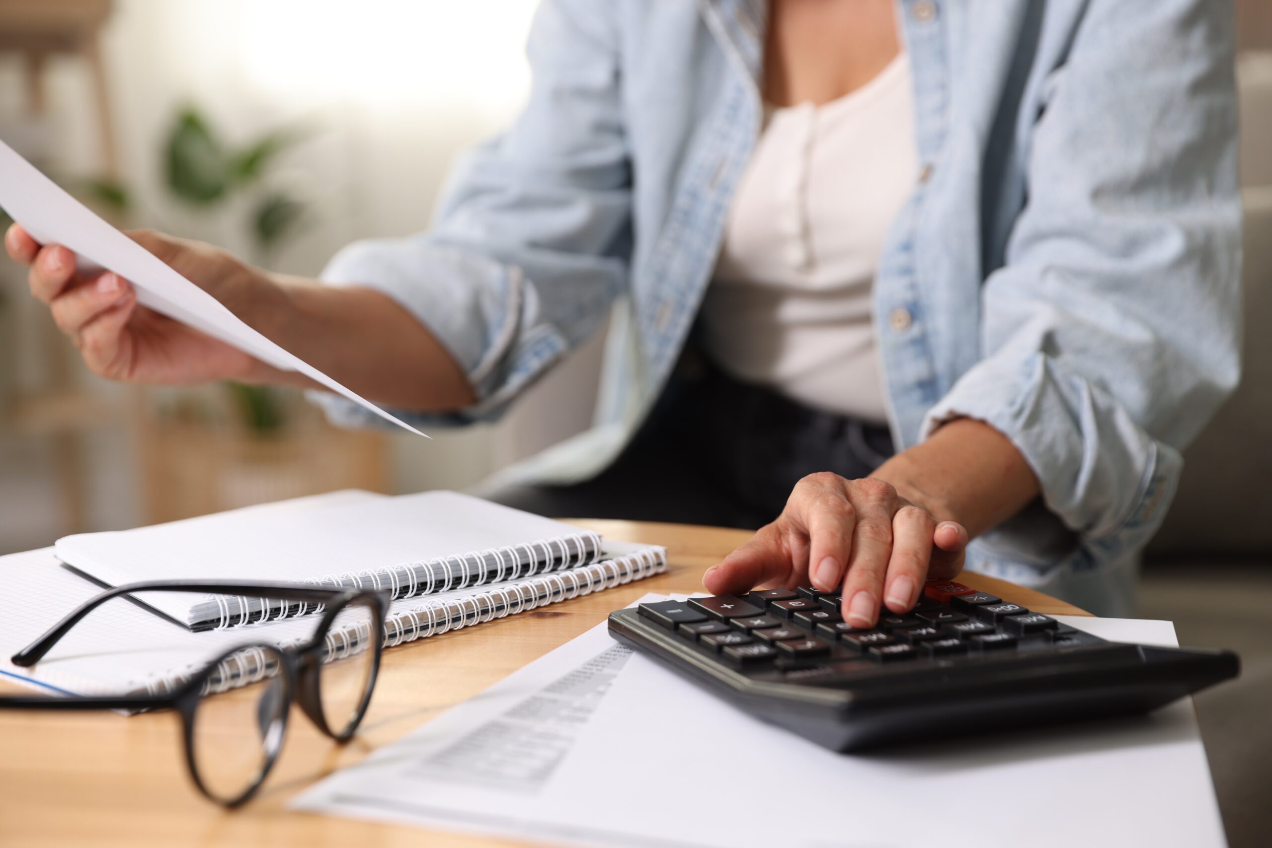 Investissement accessible : bureau avec lunettes, documents et calculatrice illustrant l’accès simplifié aux marchés financiers